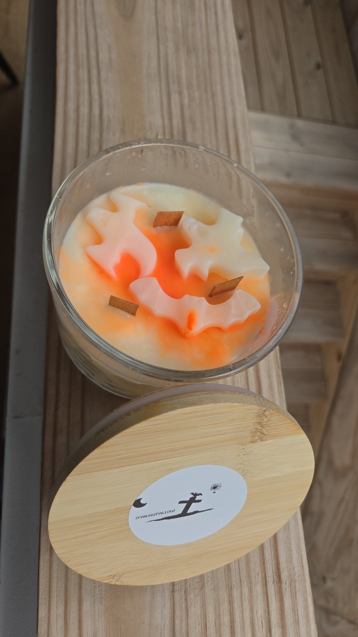 Marshmallow candle open showing orange swirl and cinnamon sticks